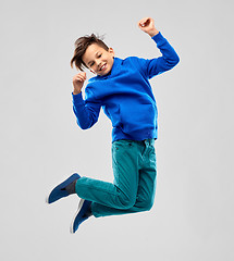 Image showing portrait of smiling boy in blue hoodie jumping