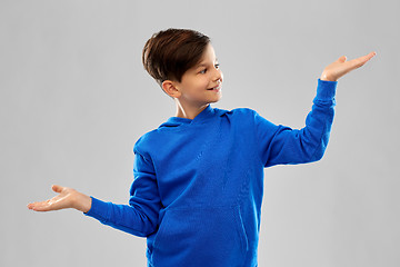 Image showing boy in blue holding something on empty hands