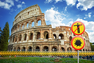 Image showing Warning signs with Coronavirus molecule and crossed out man on a background of Colosseum in Rome, Italy.