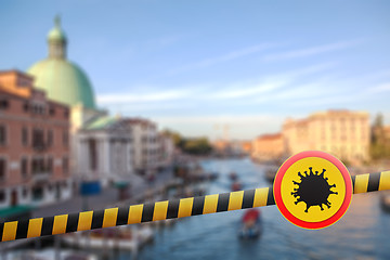 Image showing Warning sign with Coronavirus molecule on a police line on the blurred background of Grand Canal in Venice, Italy.