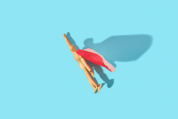 Image showing Movable human miniature model in red cape as a superman flies up.