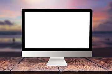 Image showing Computer mockup screen on wooden table against sea background.