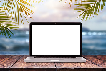 Image showing Notebook mock-up display on wooden table against sea background.