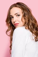 Image showing The serious business woman standing and looking at camera against pink background.