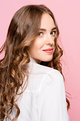 Image showing The happy business woman standing and smiling against pink background.