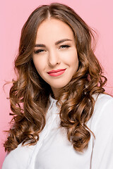 Image showing The happy business woman standing and smiling against pink background.