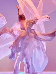 Image showing Ballerina. Young graceful female ballet dancer dancing over pink studio. Beauty of classic ballet.