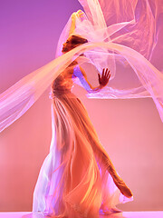 Image showing Ballerina. Young graceful female ballet dancer dancing over pink studio. Beauty of classic ballet.