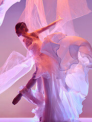 Image showing Ballerina. Young graceful female ballet dancer dancing over pink studio. Beauty of classic ballet.