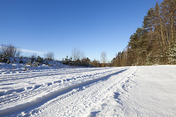 Image showing plowed agricultural field covered by snow