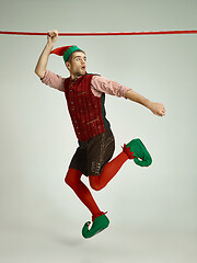 Image showing friendly man dressed like a funny gnome posing on gray background