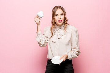 Image showing The serious frustrated young beautiful business woman on pink background