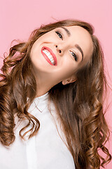 Image showing The happy business woman standing and smiling against pink background.