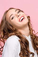 Image showing The happy business woman standing and smiling against pink background.