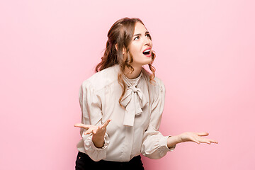 Image showing Beautiful female half-length portrait isolated on pink studio backgroud. The young emotional surprised woman