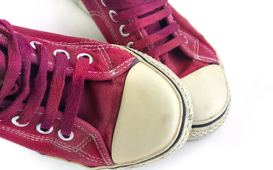 Image showing Old wine-colored sneakers on white background