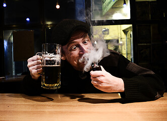 Image showing Guy smokes pipe in the bar