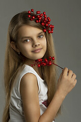 Image showing Portrait of a beautiful teenage girl with a bunch of berries in her hand and in her hair