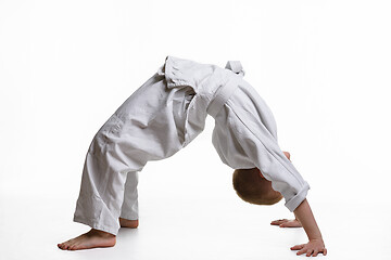 Image showing Boy athlete makes a bridge at the warm-up of the judo section