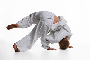 Image showing Judo boy doing warm-up spinning around himself while standing on his head