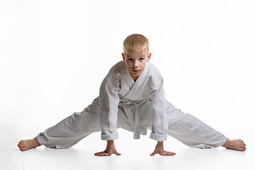 Image showing Karate boy tries to sit on a twine