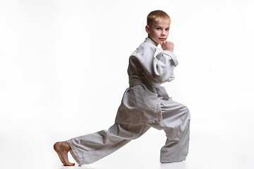 Image showing Martial arts student crouches, stretches his legs and looked into the frame