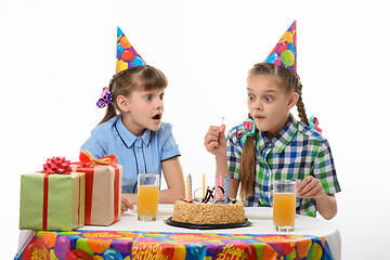 Image showing Children funny look at a lit match sitting at the festive table