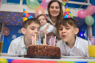 Image showing Children blew out candles on a holiday cake