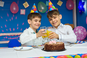 Image showing Two brothers banging glasses of juice at a birthday party