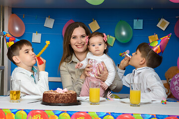 Image showing Children joyfully blow in the bells at a birthday party