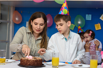 Image showing Mother and son cut a cake in honor of the birthday