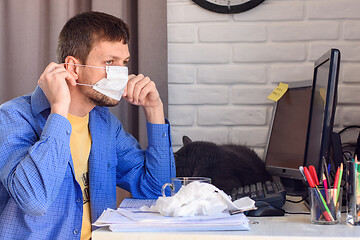 Image showing A sick quarantined man works at a computer