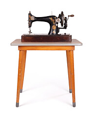 Image showing Antique, vintage sewing machine on an old table