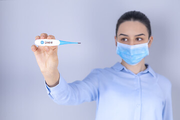 Image showing Girl with mask on face check fever