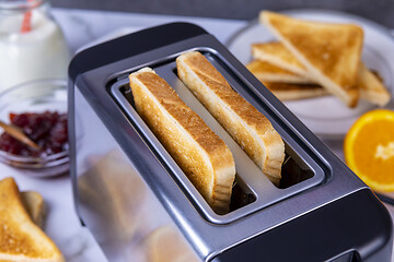 Image showing Slices of toast coming out of the toaster for healthy breakfast