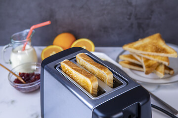 Image showing Slices of toast coming out of the toaster for healthy breakfast