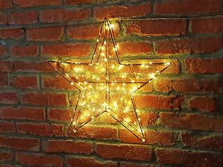 Image showing Shining yellow star on a brick wall