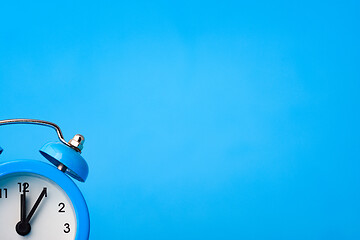 Image showing Alarm clock in the lower left corner on a blue background
