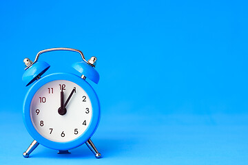 Image showing Alarm clock on a blue background, on the right is an empty place