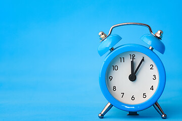 Image showing Alarm clock on a blue background, left empty space