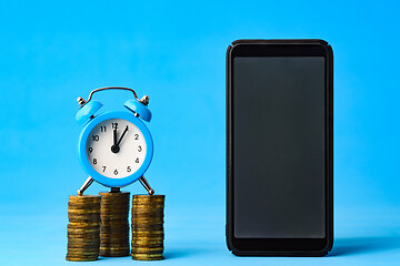 Image showing Business items - watch, stack of coins and phone on a blue background