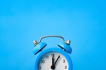 Image showing Fragment of an alarm clock and empty space above it, blue background