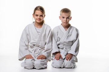 Image showing Two judo students sit on their knees and look in the frame