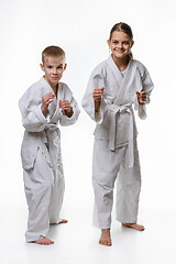 Image showing Judo boy and girl students in a rack, white background