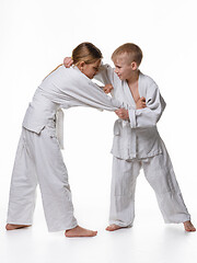 Image showing In a judo lesson, a boy and a girl fight and capture