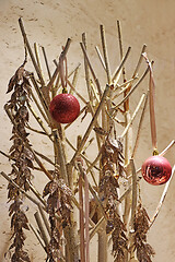 Image showing Two red christmas balls on a golden twigs as decoration