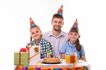 Image showing Happy dad and two daughters at the festive table in honor of the birthday