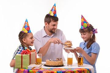 Image showing Dad puts his first piece of birthday cake on a plate for his daughter