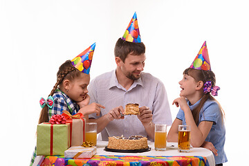 Image showing Dad offers one of his daughter a piece of festive cake