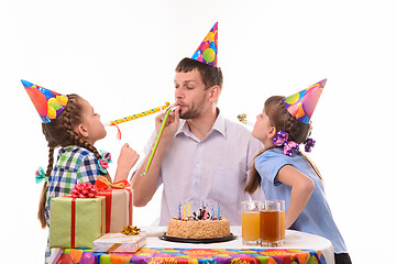 Image showing Children and dad joyfully blow whistles to the horns at a birthday party